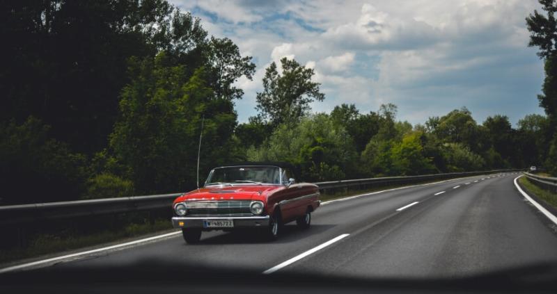 Red Car on the Road Surrounded with Trees