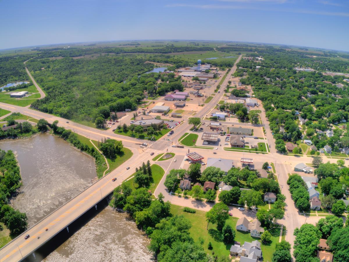 Aerial view of Granite Falls, MN town layout, greenery, and river crossing with a bridge.