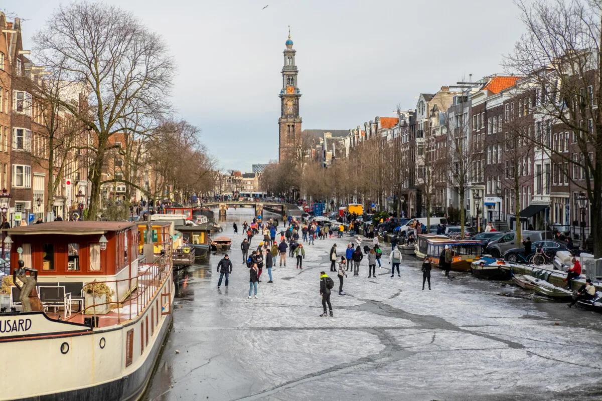 People ice skating in Amsterdam, Netherlands frozen canal