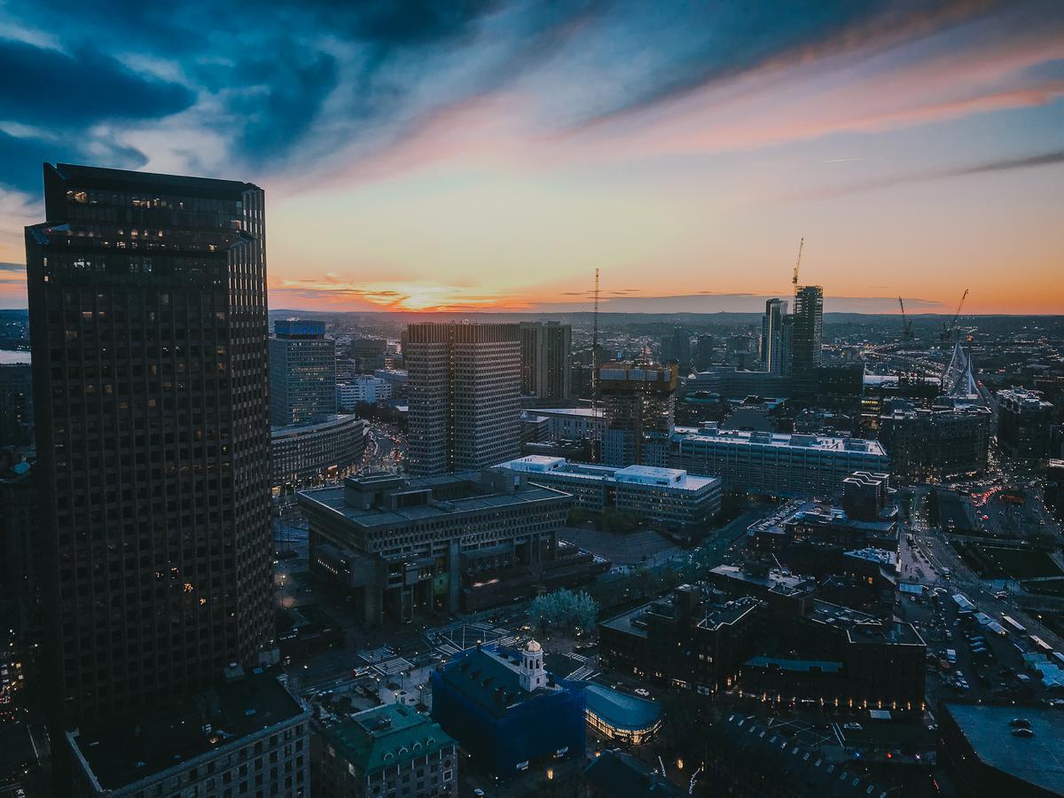 Sunset over Boston skyline with city lights illuminating