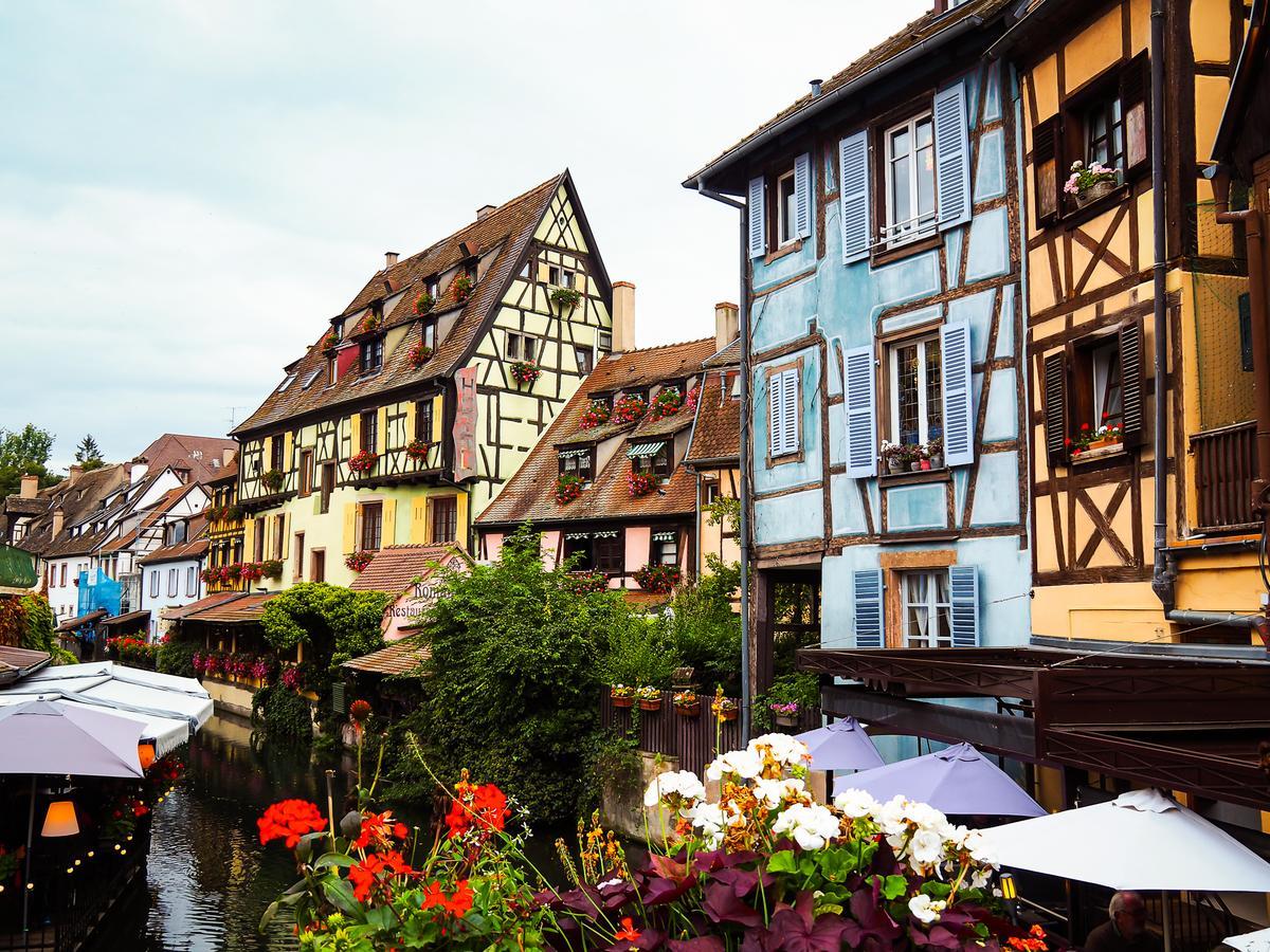 La Petite Venise in Colmar with vibrant summer view of colorful half-timbered houses and floral charm