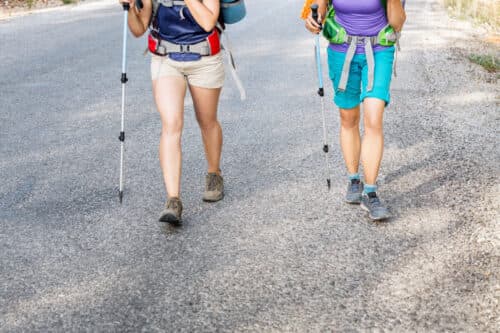 Closeup view of the hiking shorts and legs of trekking group of hikers walking together outdoors on a trail