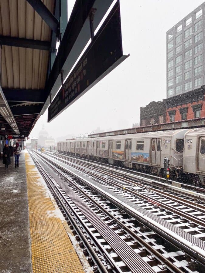 Snowfall at New York City subway station with commuters