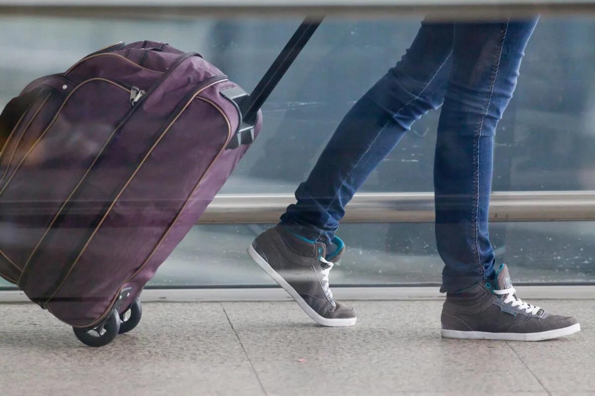 Purple rolling duffel bag being pulled through an airport during travel