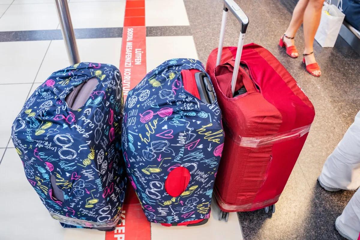 Travel suitcases in covers, in the airport hall