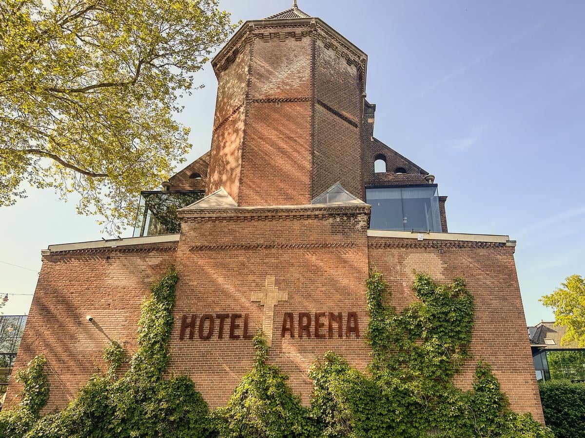 Hotel Arena Amsterdam historic brick exterior with lush greenery