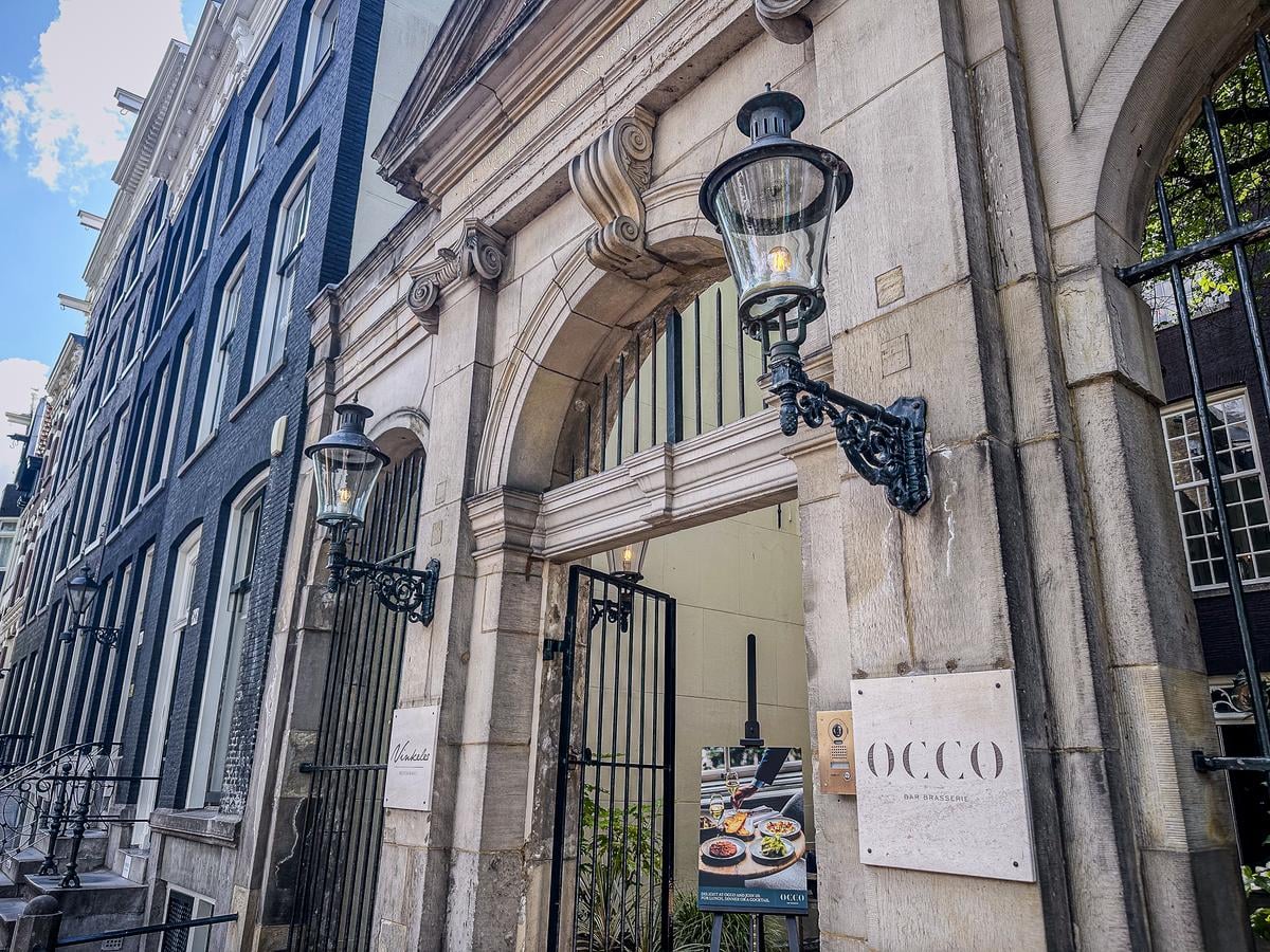Elegant entrance of The Dylan Amsterdam Hotel with historical architecture and chic brasserie sign