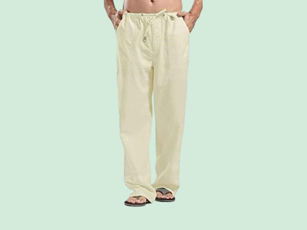 A mean wearing ivory linen pants with flip flops