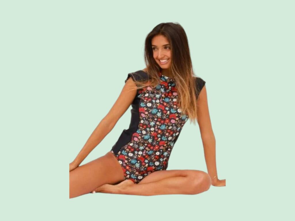 A woman wearing a short sleeved rash guard by Infamous Swim