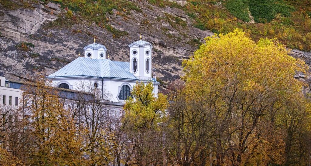 Autumn colors frame of Haus de Natur against rocky cliffs in Salzburg, Austria.