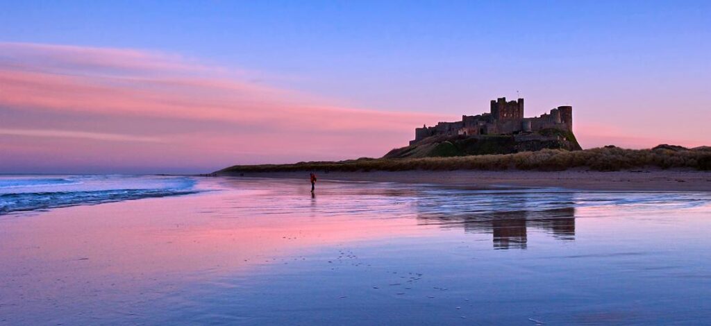 Bamburgh Castle at sunset above the Northumberland coast
