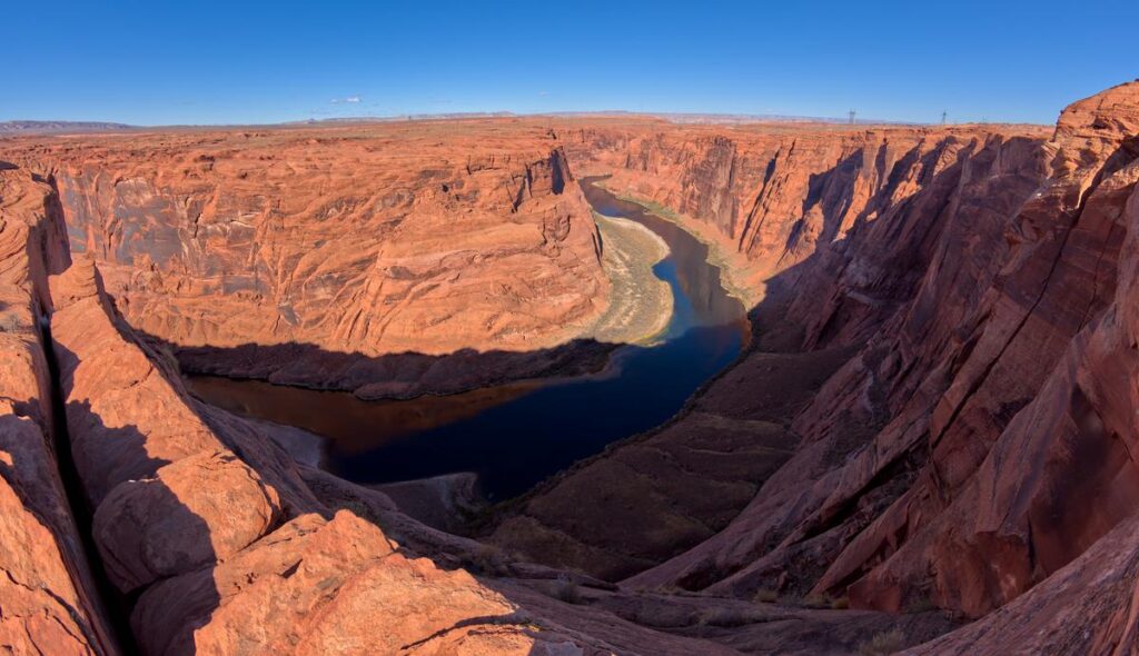 Breathtaking view of the Colorado River meandering through red sandstone cliffs near Glen Canyon Dam and Horseshoe Bend, Arizona.
