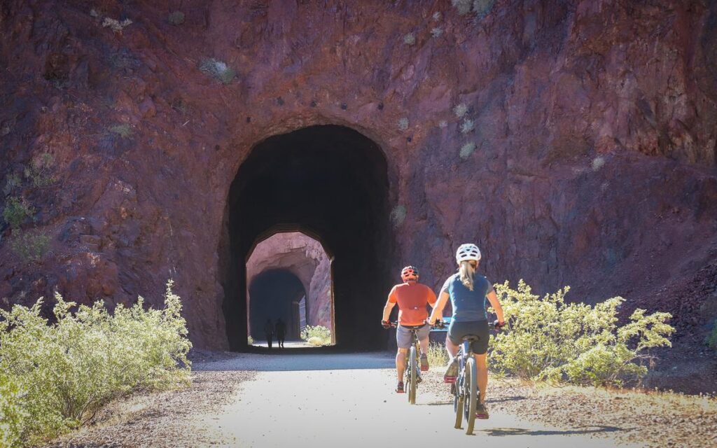 Cyclists exploring historic railroad tunnels near Lake Mead on a sunny day