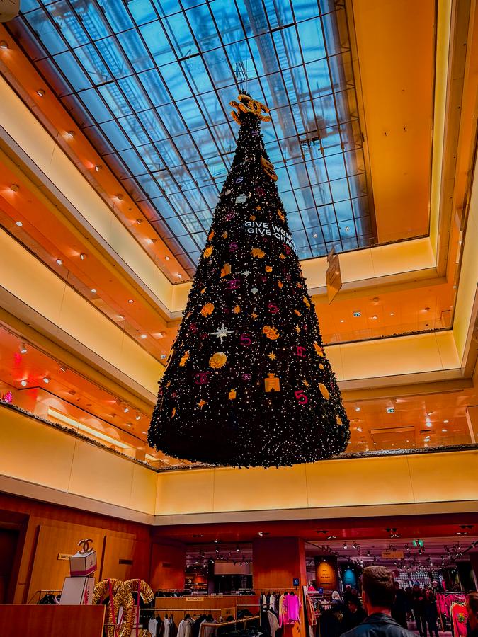 Inside De Bijenkorf Amsterdam during Christmas with festive decorations and holiday shopping