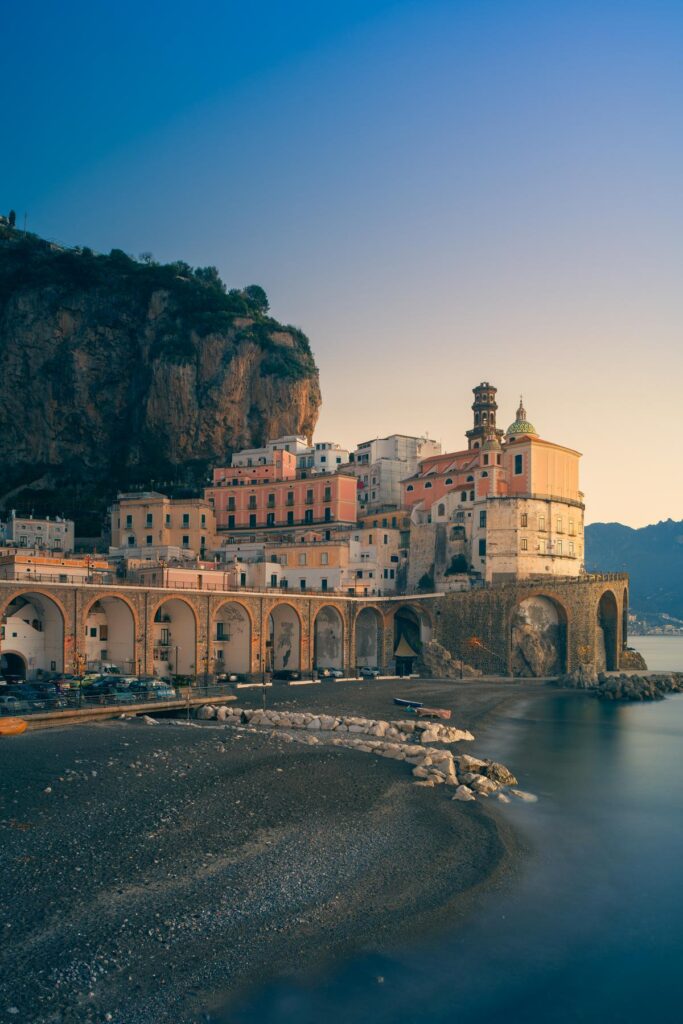 Atrani beach, arches, and hillside buildings at dusk
