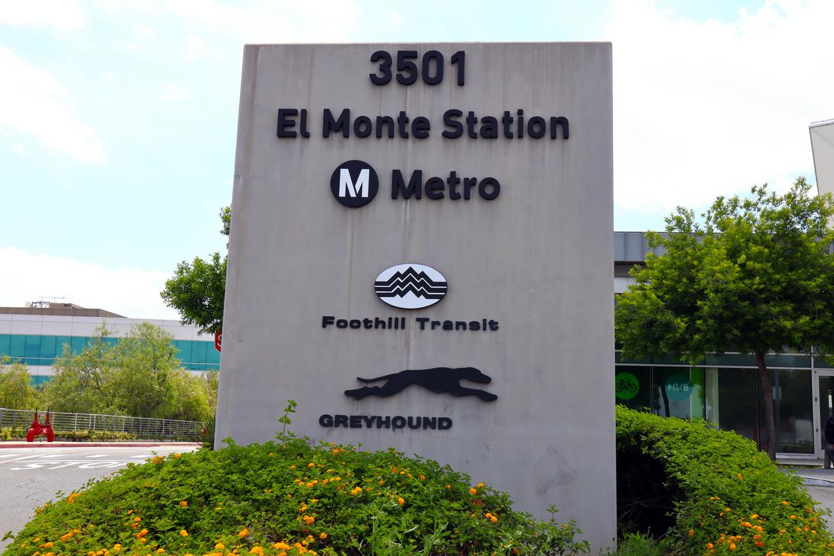 El Monte Station Metro sign in Los Angeles with Foothill Transit and Greyhound logos, surrounded by greenery.