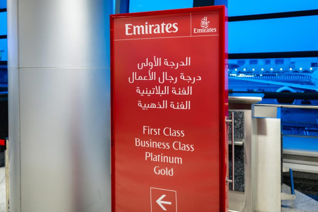 Emirates priority boarding sign with airport backdrop