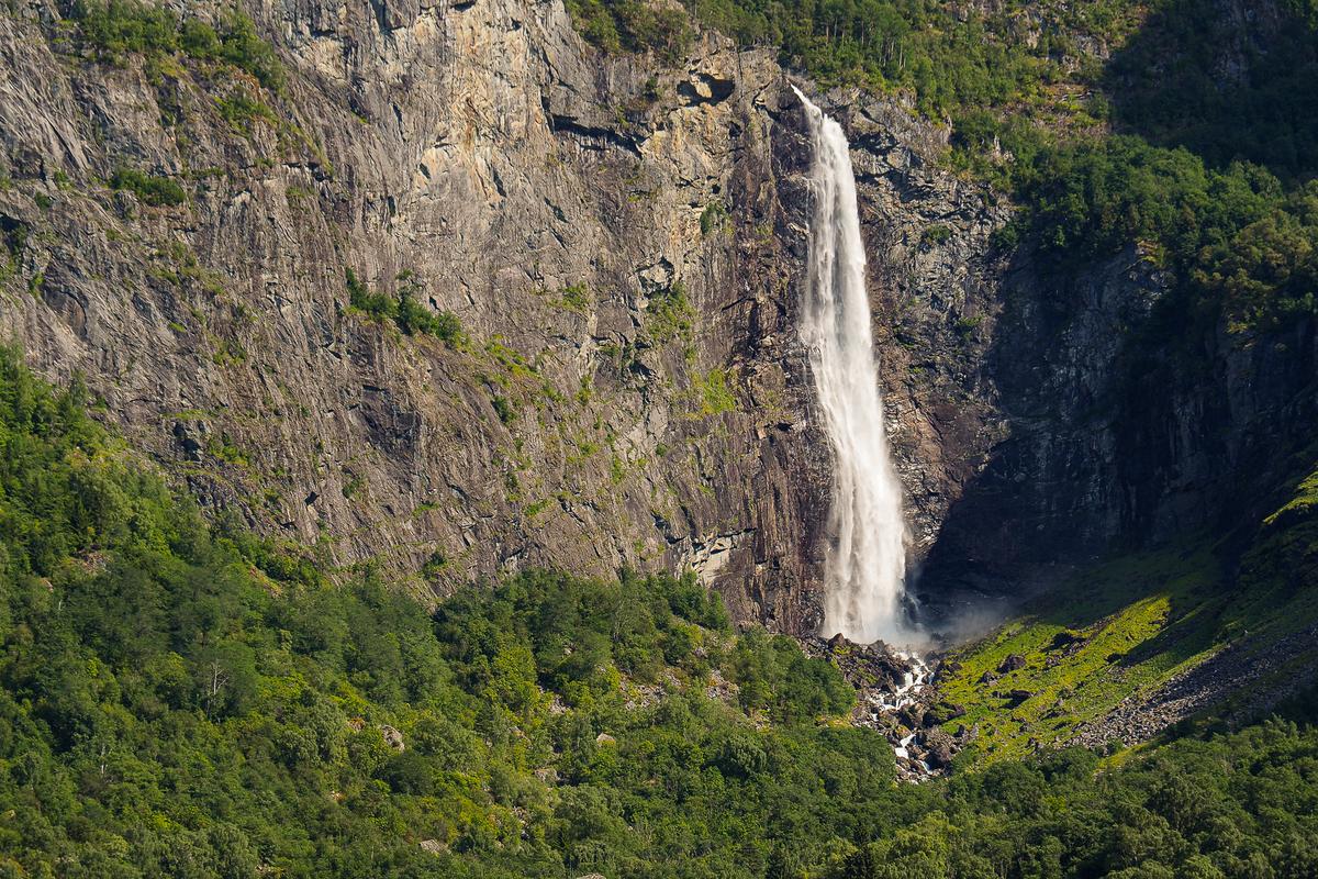 Feigumfossen Waterfall close-up cascading from cliff surrounded by lush forest in Norway