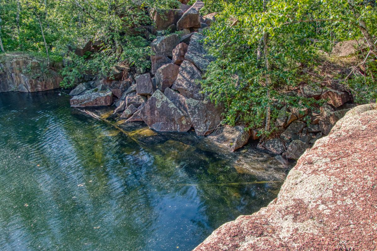 Granite quarry surrounded by greenery at Quarry Park Reserve, one of the best things to do in St. Cloud, Minnesota