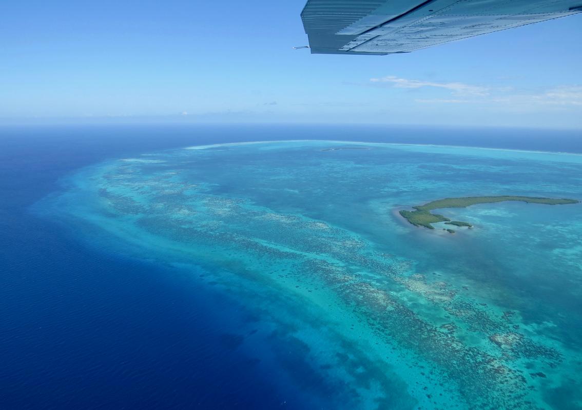 Great Blue Hole centered within the shallow turquoise water of Lighthouse Reef