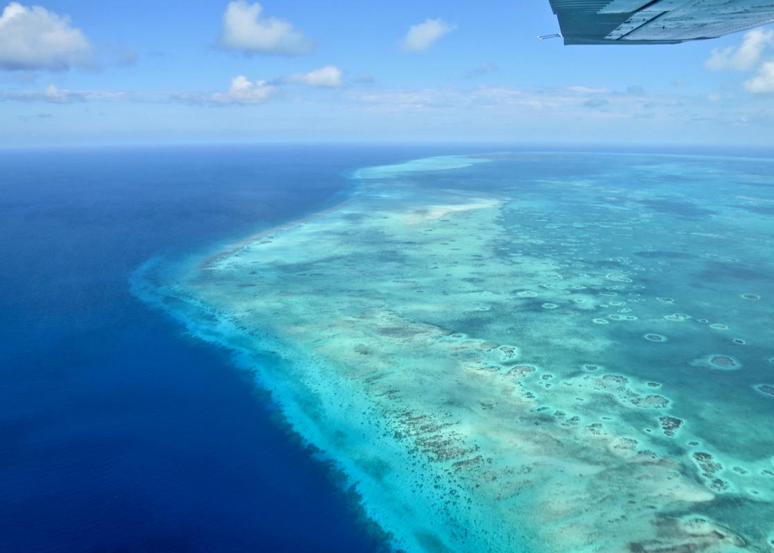 Aerial view of the Great Blue Hole with a dive boat near the coral rim