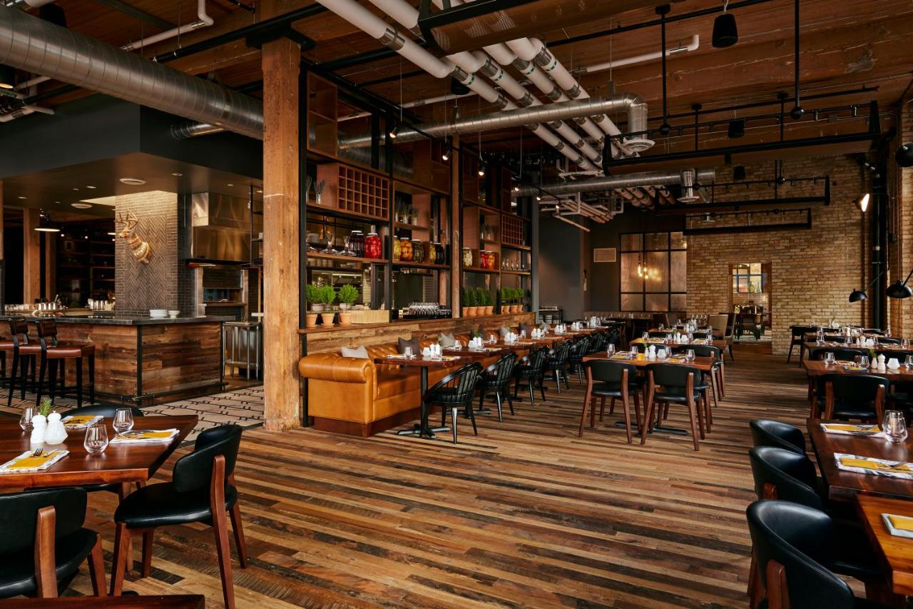 Rustic restaurant with wooden tables and black chairs, vintage paintings and photographs on the walls