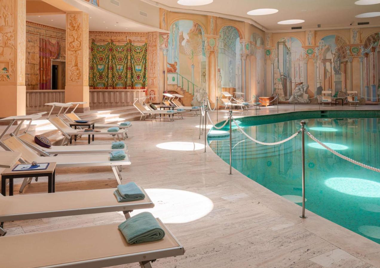 Indoor swimming pool with lounge chairs at Hilton Sorrento Palace hotel.