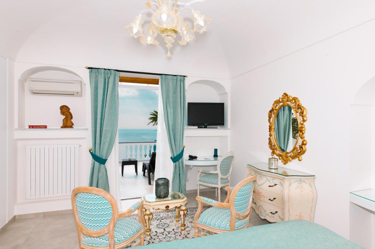 Cozy and well-furnished hotel room with a comfortable bed, wooden table, and matching chairs, reflecting spaciousness and warmth at Hotel Villa Gabrisa.