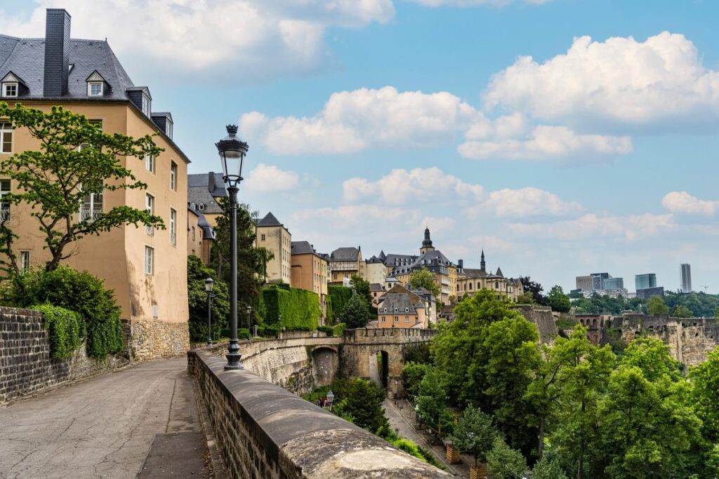 Scenic panoramic view of Luxembourg City with historic architecture and lush greenery under a clear blue sky.