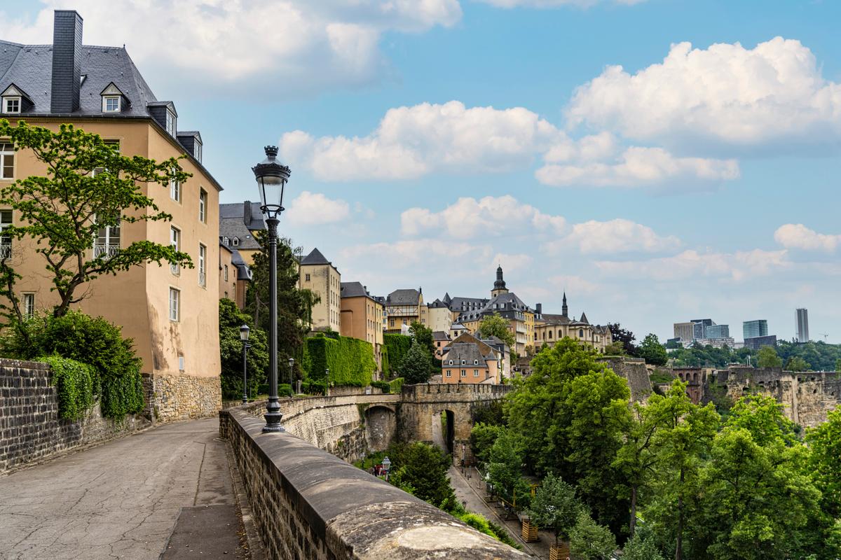 Scenic panoramic view of Luxembourg City with historic architecture and lush greenery under a clear blue sky.