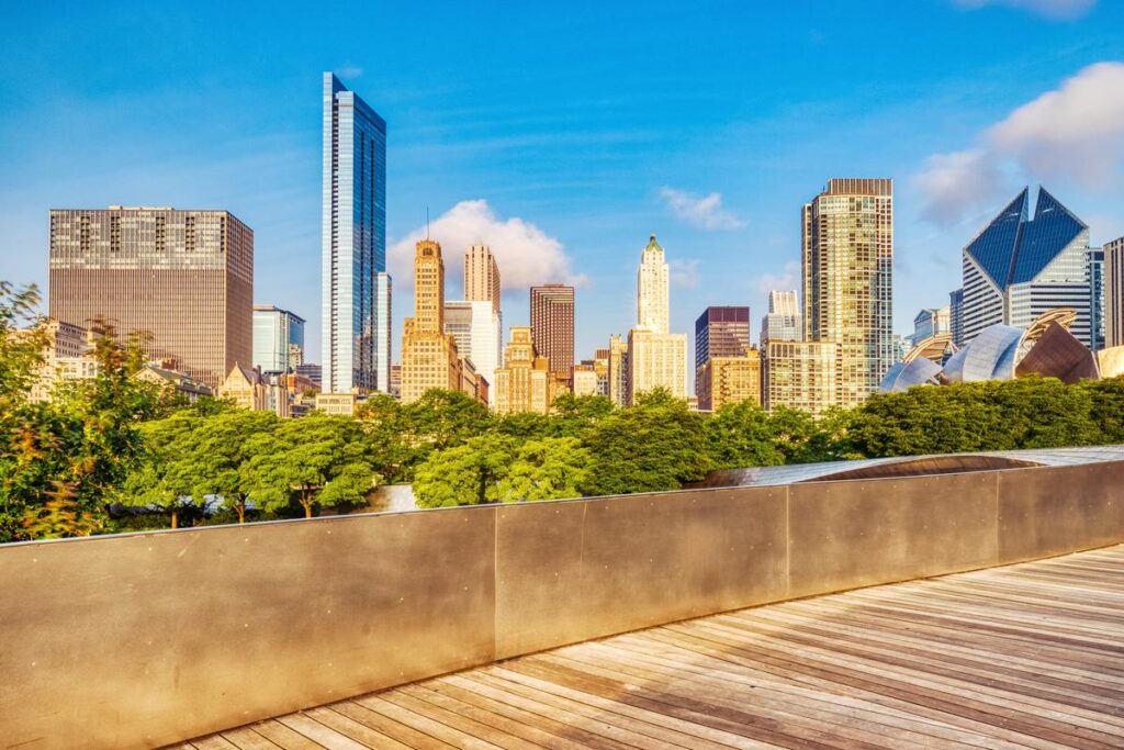 Gehry-designed bridge at Millennium Park with Chicago skyline backdrop on a sunny day