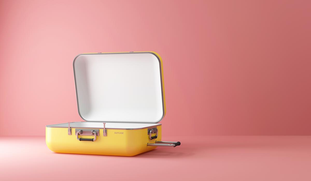 Yellow open suitcase on pink background, minimalist packing.