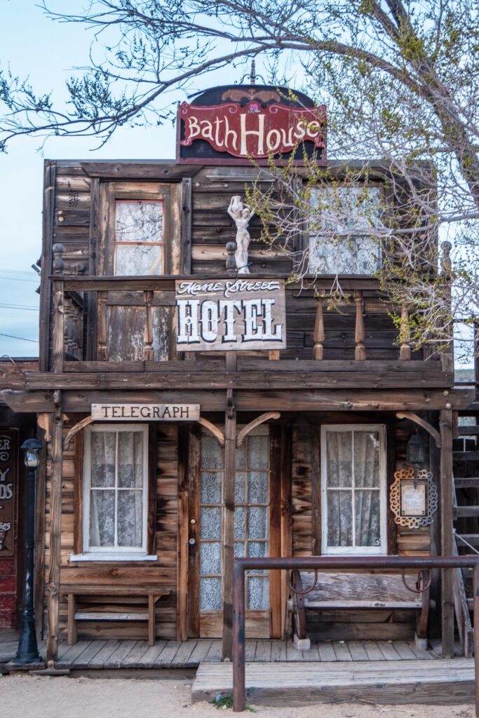 Vintage wooden hotel facade in Pioneertown with 'Bath House' sign, embodying Old West charm and history.