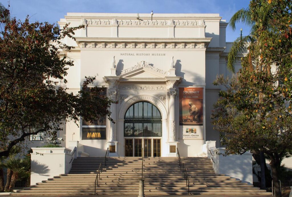 Sunlit facade of San Diego Natural History Museum, architectural detail, with Maya exhibit signage.
