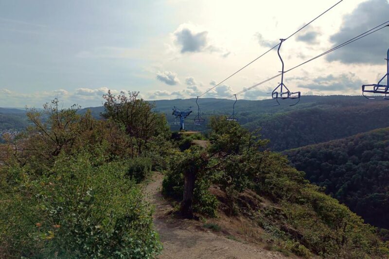 Mountain peak in the Middle Rhine Valley with scenic chairlift and lush greenery.