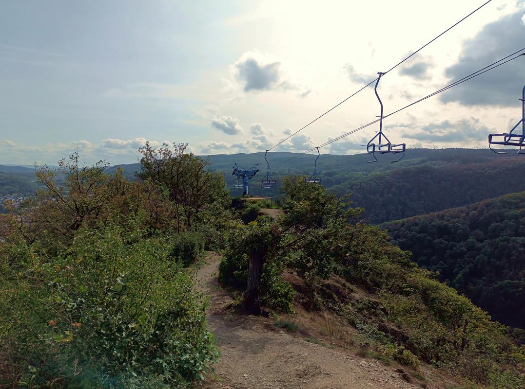 Mountain peak in the Middle Rhine Valley with scenic chairlift and lush greenery.