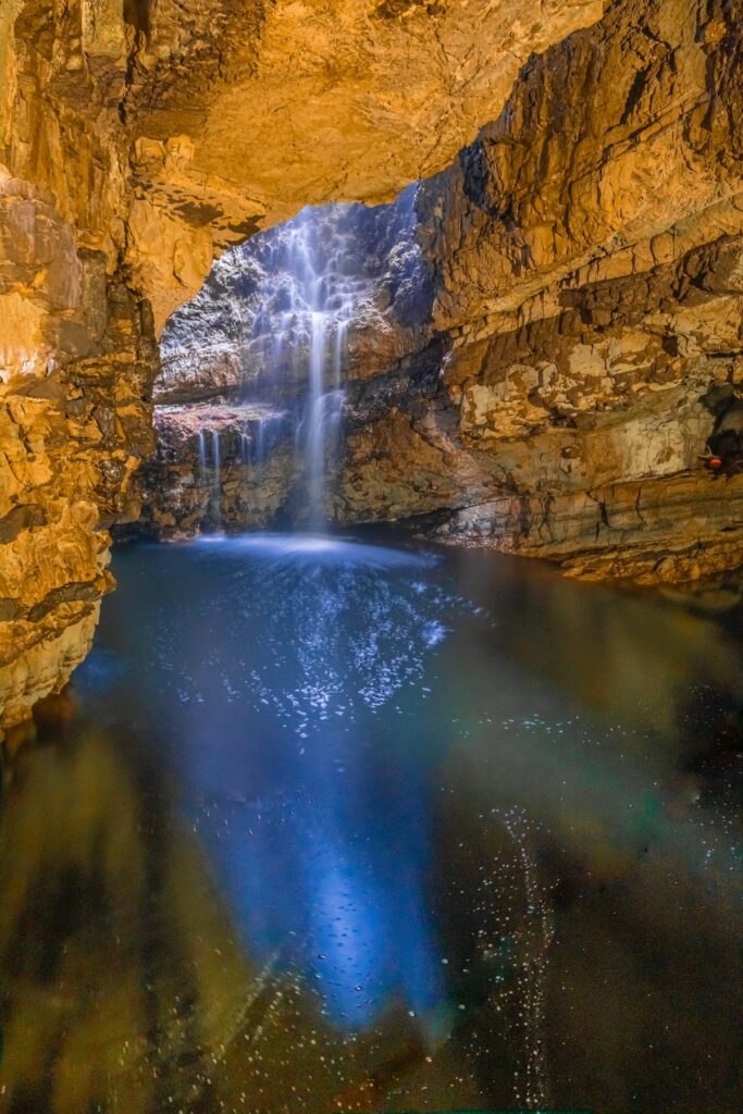 Majestic Smoo Cave with cascading waterfall in Scotland.
