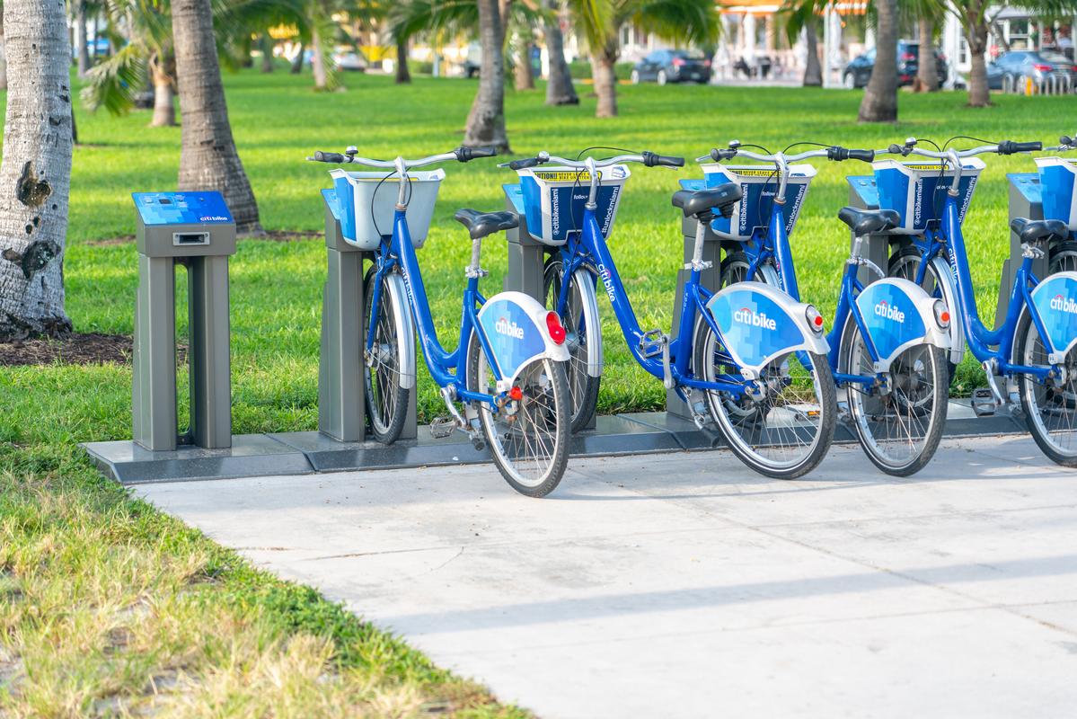 Citibike rental station in South Beach, Miami, with blue bikes lined up against green parkland backdrop.