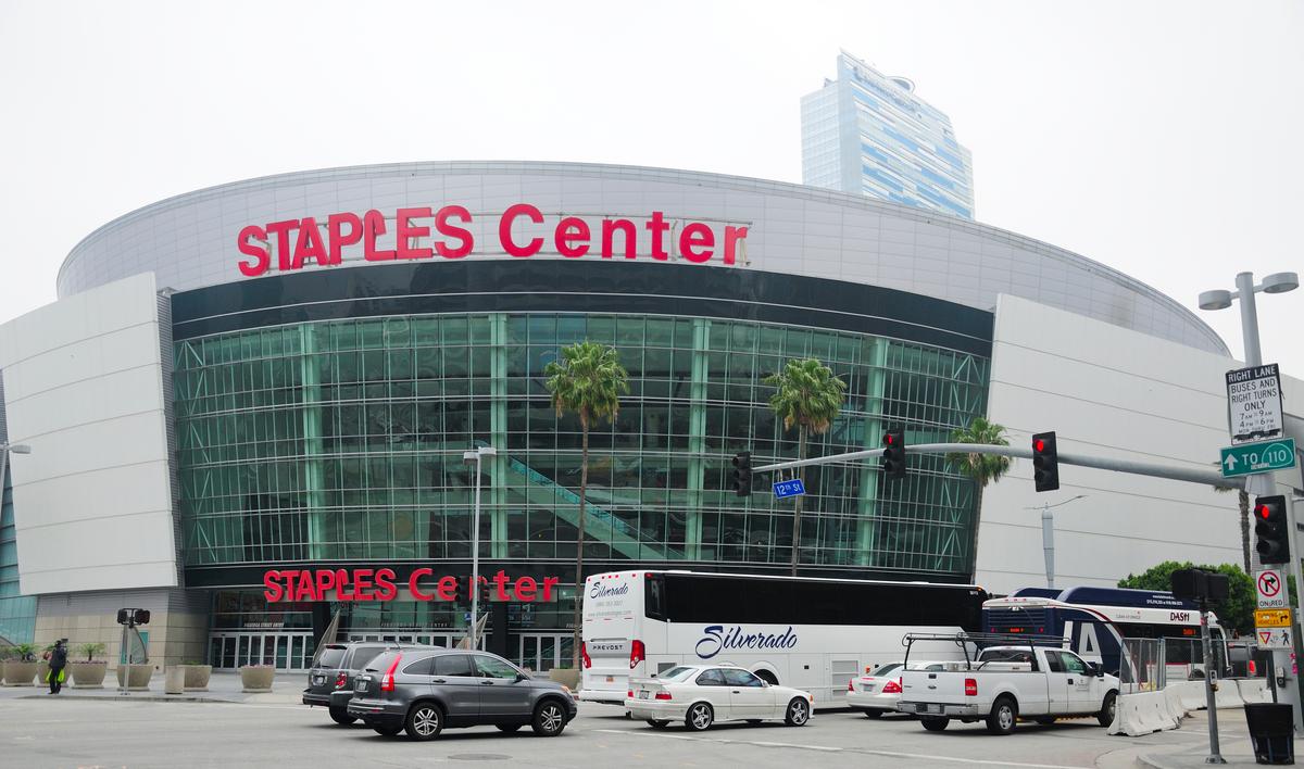 Traffic in front of Staples Center in downtown Los Angeles, showcasing bustling city life and iconic landmarks.