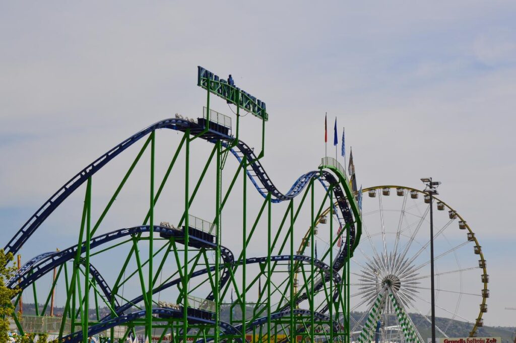 Rollercoaster and Ferris wheel at Stuttgart Spring Festival, Germany, vibrant amusement park rides, travel and leisure concept.