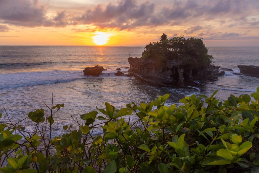 Tanah Lot Temple silhouetted against a sunset in Bali