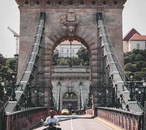Motorcyclist crossing Széchenyi Chain Bridge Budapest, historical architecture, vertical view