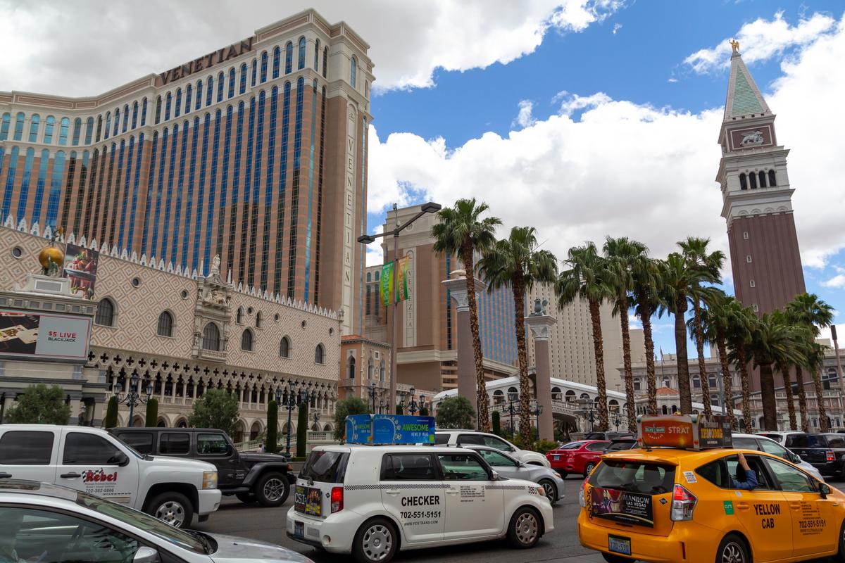 Taxis on the Las Vegas Strip in front of The Venetian Resort, featuring iconic architecture and palm trees.