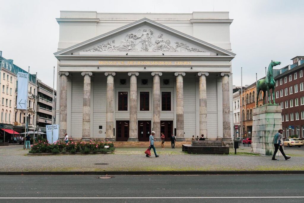 Theater Aachen facade with classic columns and bustling street scene, Theater Aachen.jpg