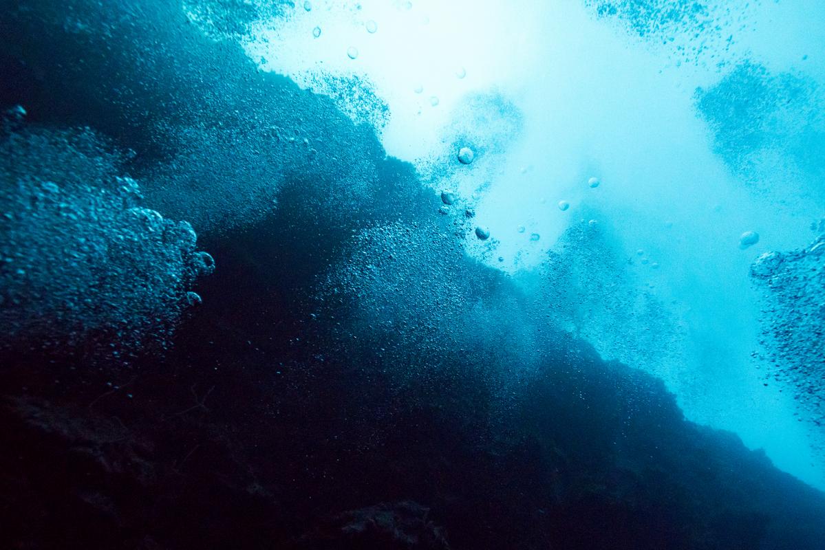 Scuba diver beside limestone formations inside the Great Blue Hole