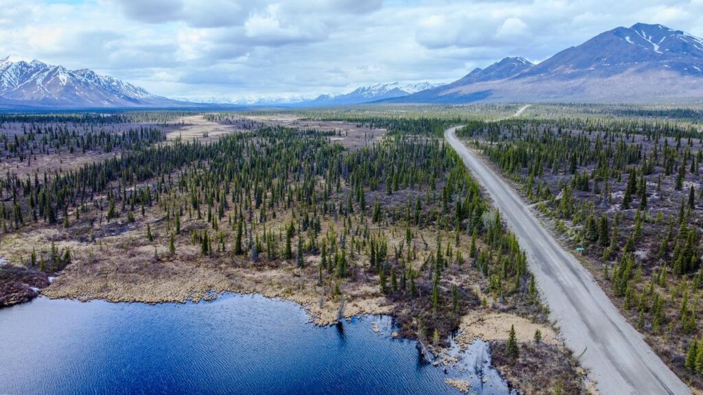 Aerial view of Denali Highway winding through scenic tundra landscape in Alaska