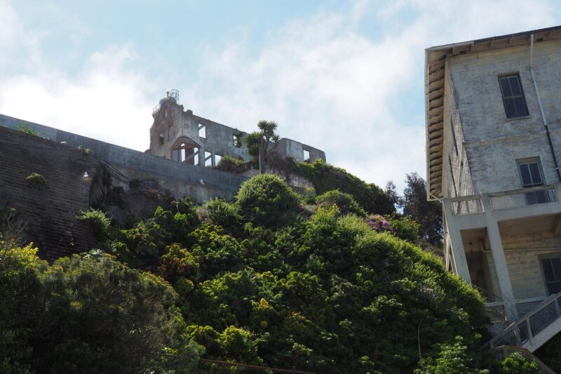 Visitors exploring historic Alcatraz Island ruins against San Francisco Bay