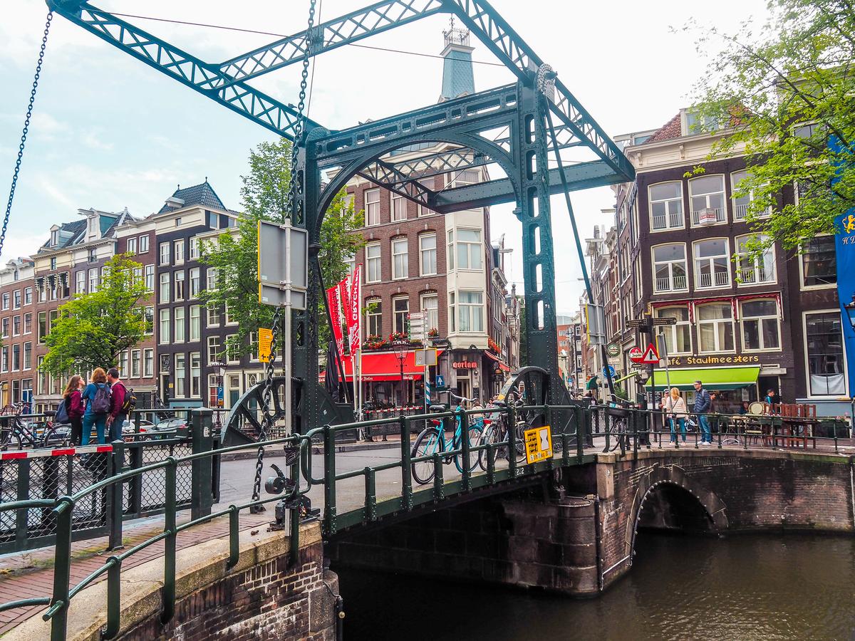 Amsterdam canal with historic metal bridge and Dutch architecture