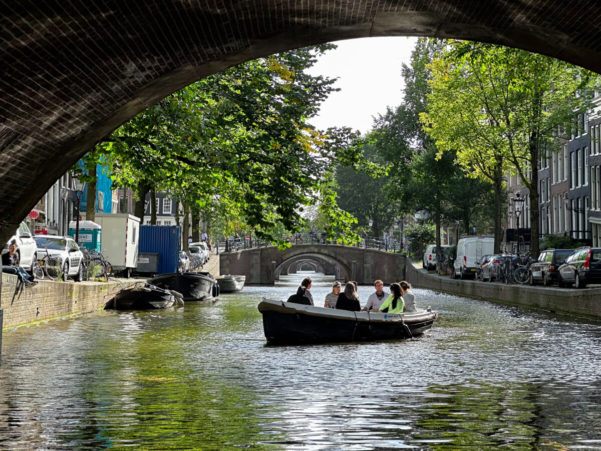 Canal tour boat passing historic houses in central Amsterdam