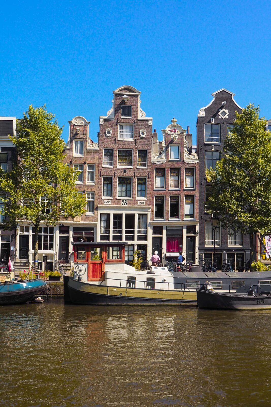 Amsterdam canal houses with gables and boats on waterway